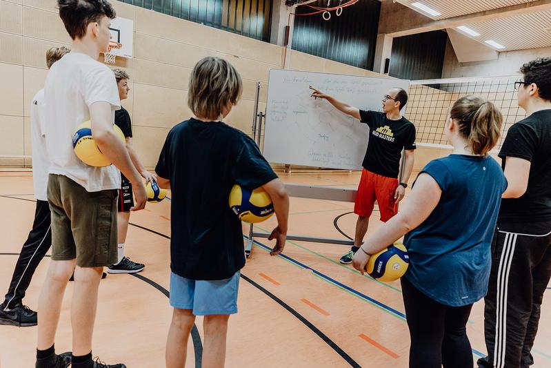 Gruppe von Schüler*innen in einer Sporthalle