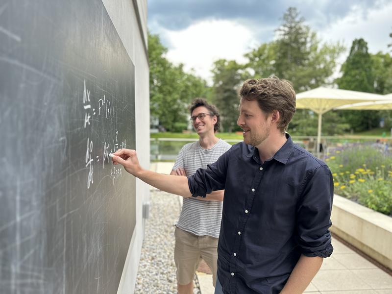 Tafel und Kreide. Edouard Hannezo (hinten) und David Brückner (vorne) brainstormen mathematische Gleichungen an einer der vielen Tafeln, die auf dem ISTA-Campus zu finden sind. Diese ermöglichen den spontanen Austausch von Ideen.