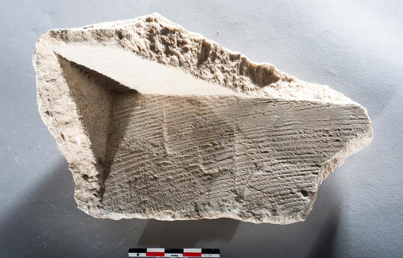 Querschnitt eines Karbonatfragments aus den Mühlen von Barbegal. Die Ablagerung hat sich auf dem Holz der Mühlräder gebildet und zeigt Abdrücke von Holz und Spuren der Holzbearbeitung.