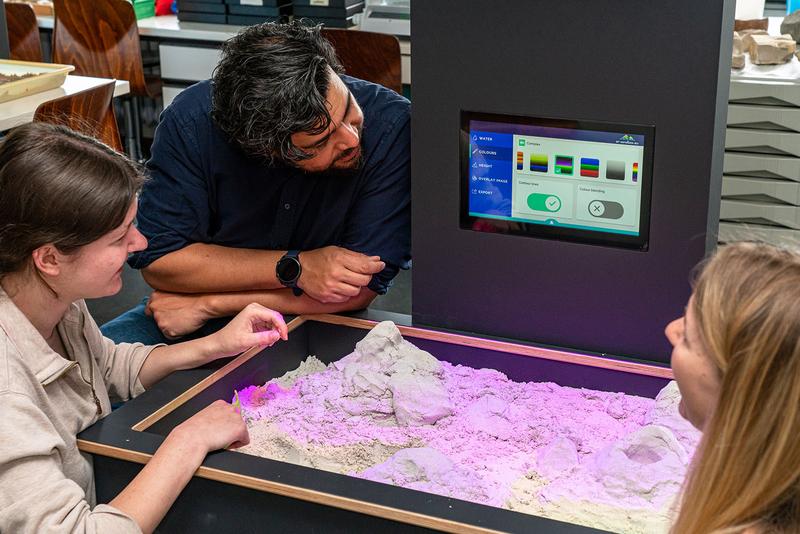 Prof. Jara mit Studierenden an der AR-Sandbox