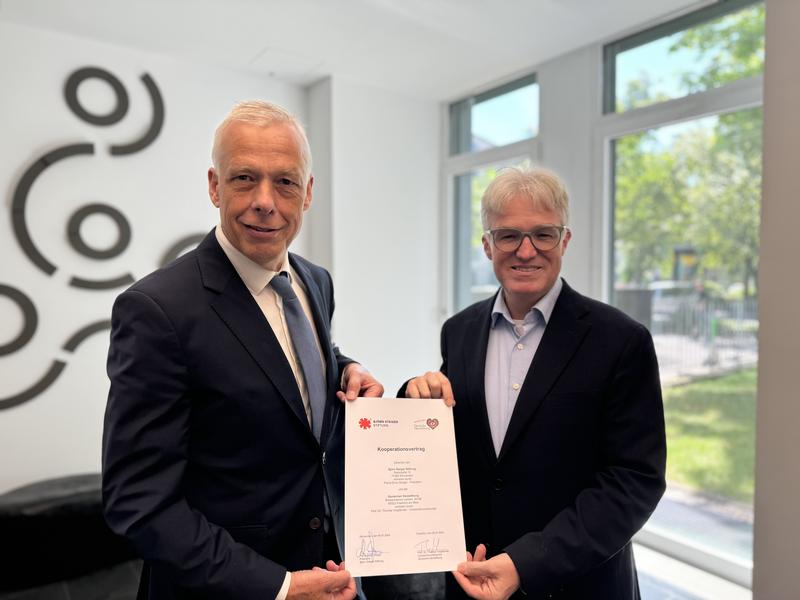 Starke Partner bündeln ihre Kräfte: Professor Thomas Voigtländer (l.) und Pierre-Enric Steiger (r.) mit dem unterzeichneten Kooperationsvertrag „Herzsicher – Gemeinsam Leben retten“.