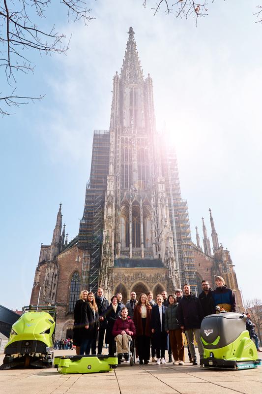 The members of the ZEN-MRI consortium with robots in front of the Ulm Minster