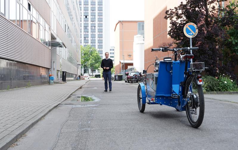 Dr. Tom Assmann ruft das autonome Lastenrad zu sich.