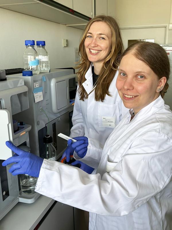 Dr. Carina Jacobsen (first author) and Nina Plückebaum (second author) with the device used to measure the interaction between the viral protein (glycoprotein C) and interferon.