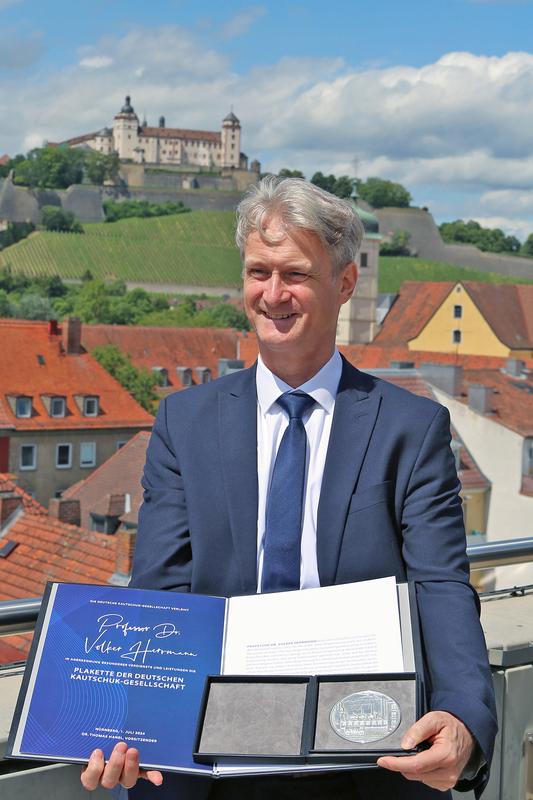 Prof. Dr. Herrmann, Fakultät Kunststofftechnik und Vermessung, mit der Auszeichnungsurkunde und Verdienstplakette der DKG 