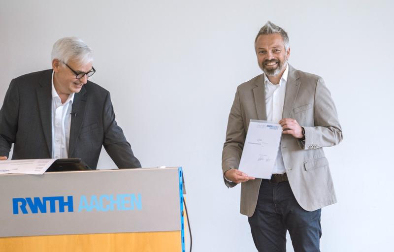 Anlässlich der Feierstunde zum 60-jährigen Bestehen des Instituts für Kommunikationssysteme (IKS) überreichte Prof. Dr.-Ing. Albert Moser (l.), Dekan der Fakultät für Elektrotechnik und Informationstechnik, Professor Adrat die Ernennungsurkunde.