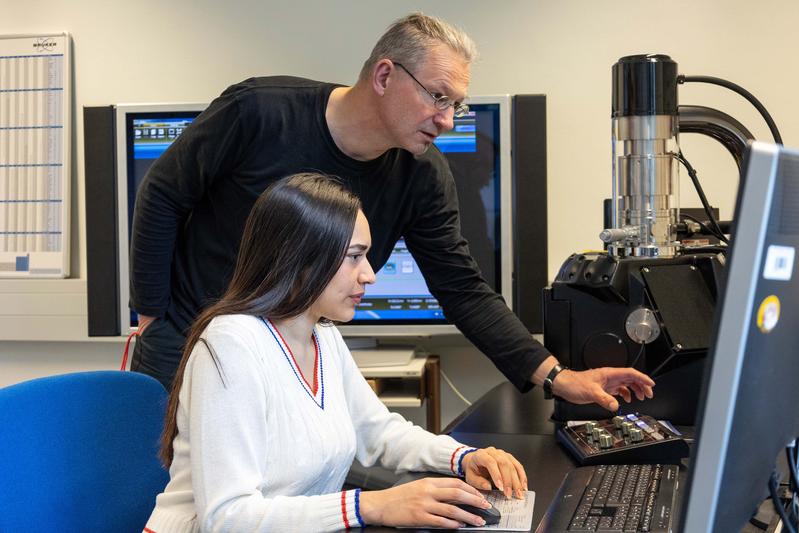 Eine Maschinenbau-Studentin arbeitet an einem Projekt. Dabei wird sie von ihrem Dozenten gecoacht.