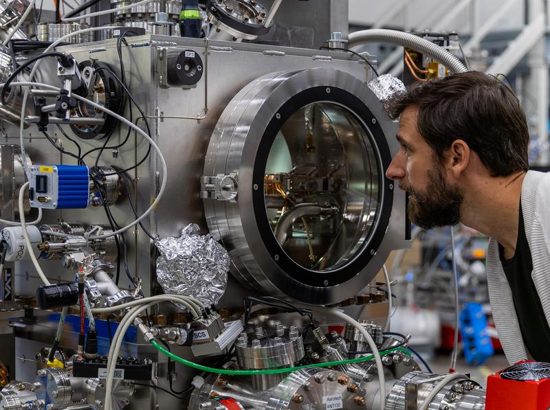 Laurent Mercadier checks the setup in the experimental chamber