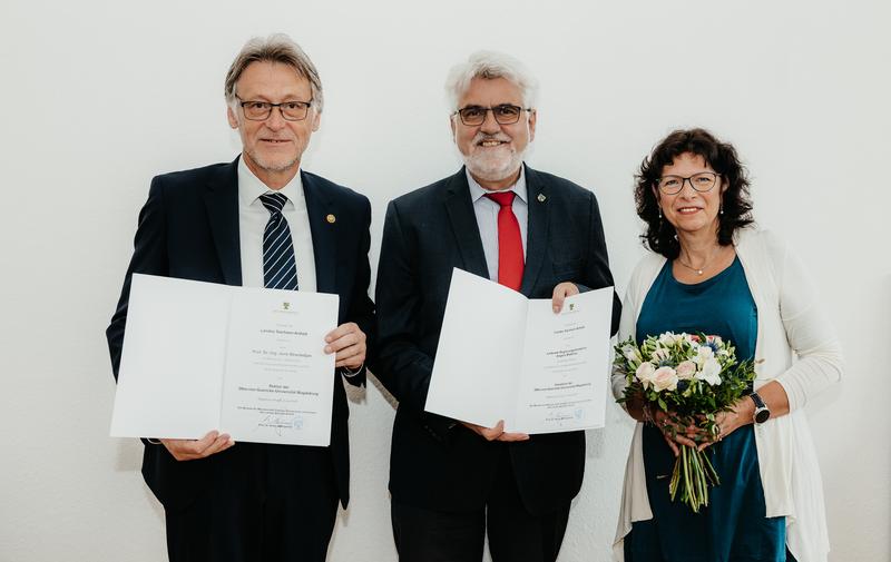 Der Wissenschaftsminister des Landes Sachsen-Anhalt, Prof. Armin Willingmann (Mi.), übergibt die Ernennungsurkunden an den Rektor der Universität, Prof. Dr.-Ing. Jens Strackeljan (li.), sowie die Kanzlerin, Angela Matthies (re.). 