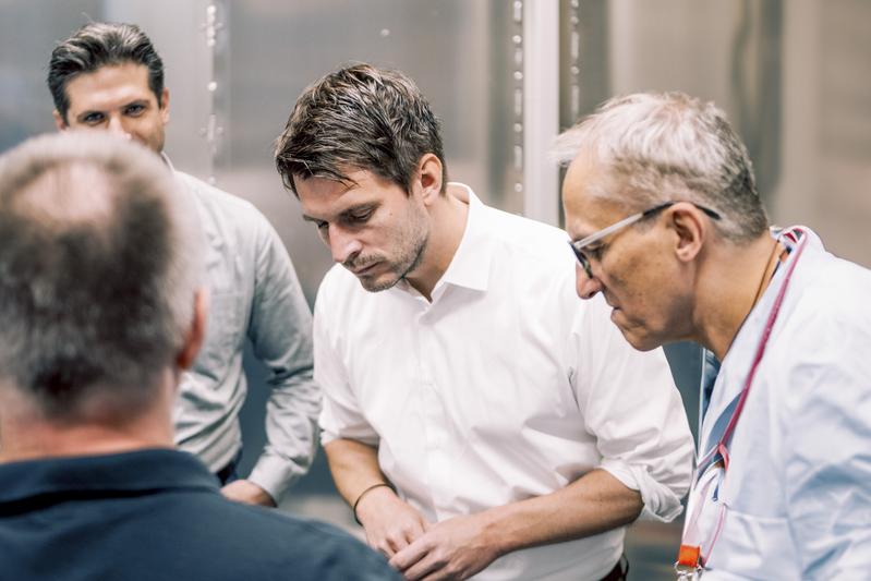 Besonderes Augenmerk legt der Staatssekretär (Mitte) auf eine Materialprobe, die mit dem Transmissionselektronenmikroskop untersucht werden soll.