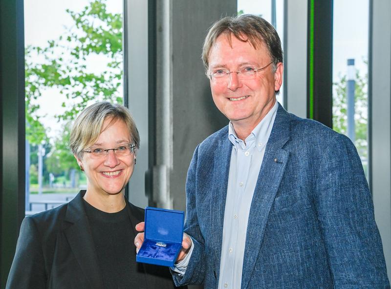 Rektorin Prof. Dr. Angelika Epple übergibt die Ehrennadel der Universität Bielefeld an Prof. Dr. Fred Becker.