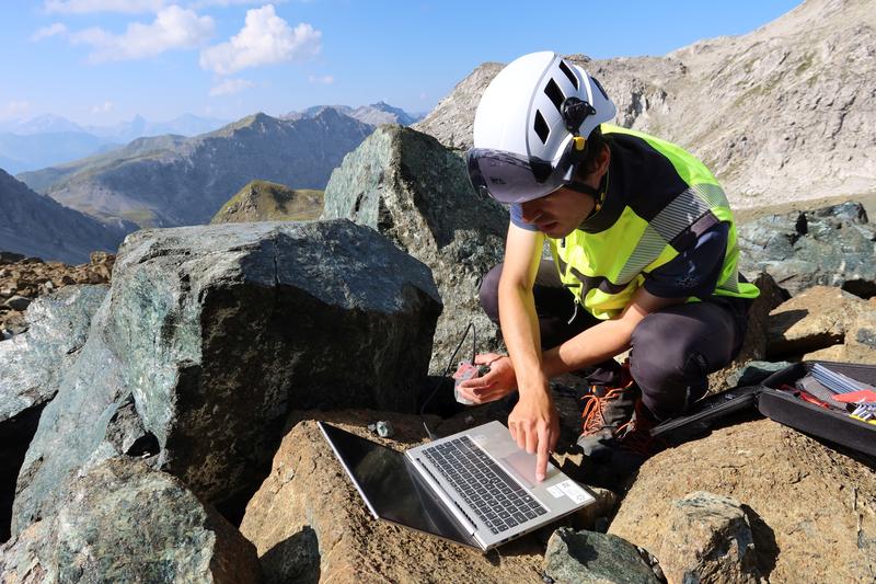 SLF rockfall expert Joël Borner downloads the data measured by the sensor installed inside the rock directly on site.