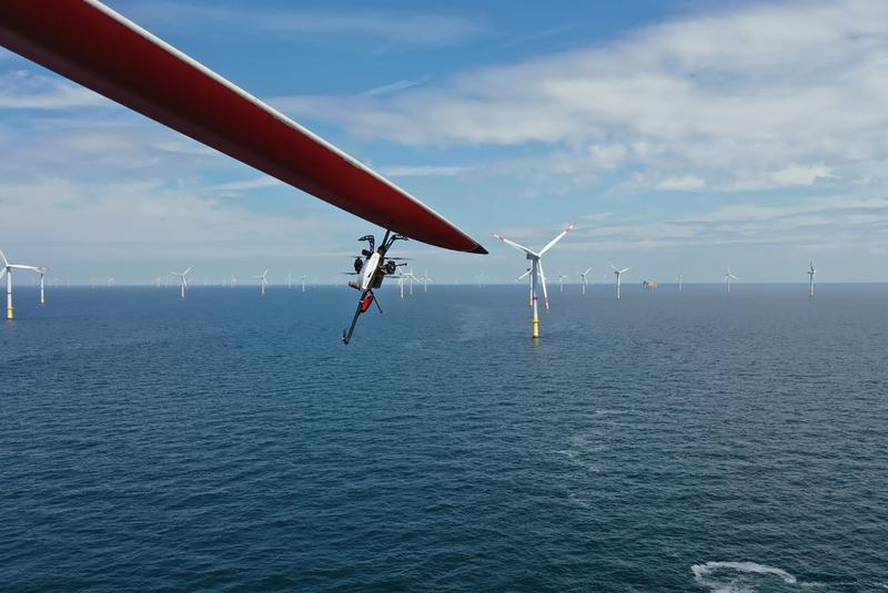 Kontrolle des Blitzschutzsystems einer Windkraftanlage im Offshore-Windpark mit einer Drohne in ca. 100 m Höhe. Riskante Arbeiten für Menschen, wie diese Inspektion, können in Zukunft vermehrt mit unbemannten Systemen realisiert werden. 