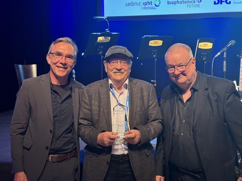 Professor Dr. Dr. h.c. Wolfgang Kiefer (center) received the Lifetime Achievement Award at the international ESULaB conference in Jena on Sept. 17, 2024. The laudation was given by Prof. Dr. Jürgen Popp (left, Leibniz-IPHT) and Dr. Peter Vogt (Coherent).