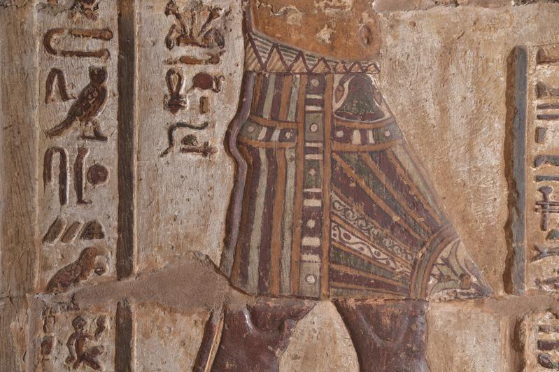 Der Schurz des Königs mit aufgemalten Pflanzen. Der Papyrus (oben) ist die Pflanze von Unterägypten und die Lilie (unten) die Pflanze von Oberägypten.