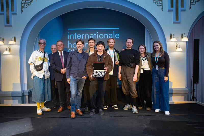 Abb.: KHM-Student Lucas Dülligen mit seinem Kameramann und Kommilitonen Mattis Schulte bei der Preisverleihung mit Juror Hans Steinbichler und Festivalleiter Thorsten Schaumann (1. v. links) Credit: Hofer Filmtage 2024