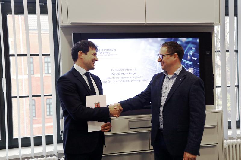 Prof. Werner König, Dekan des Fachbereichs Informatik, überreicht Prof. Paul F. Langer die Berufungsurkunde (v. re.)  