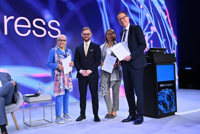 Preisträger Dr. Maximilian Friedrich mit der Stifterin Ursula Müller (links), Stiftungskuratoriumsmitglied Katja Engelbert (2. v. r.) und DGN-Präsident Prof. Dr. Lars Timmermann (rechts) während der Verleihung beim DGN-Kongress.