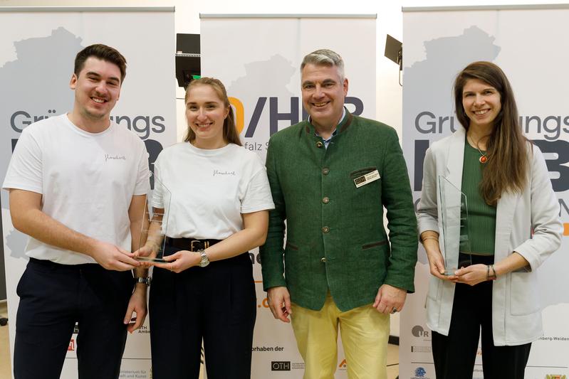 Prof. Dr. Sean Patrick Saßmannshausen, Leiter des Start-up Centers der OTH Regensburg, überreichte die Pokale des Pitch-Wettbewerbs an Thea Kakavand (r.) von Lesson Organizer, und an Elisabeth Hockemeyer (2. v.l.) und Julian Höpfner (l.) von FlowHerb.