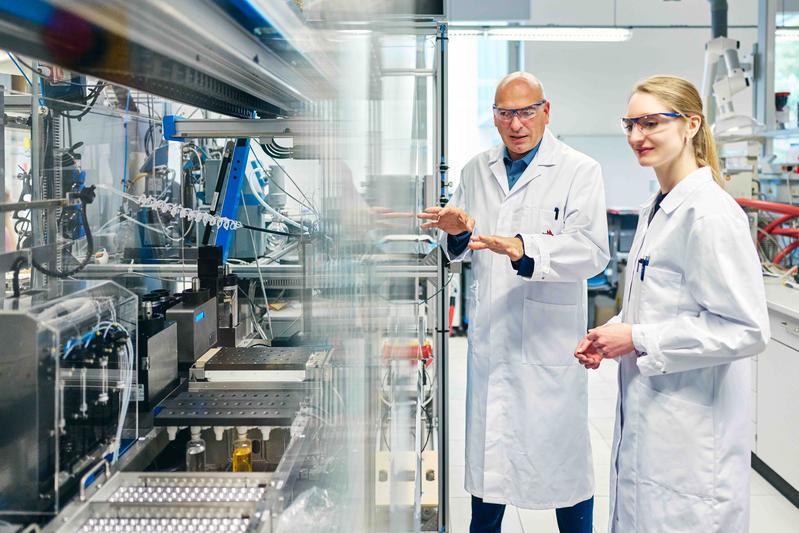 Prof. Dr. Ulrich S. Schubert und Dr. Natalie Göppert von der Universität Jena vor einem Syntheseroboter zur automatischen Durchführung von Copolymerisationen.