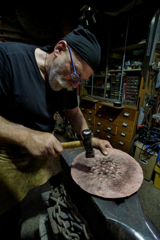 The copper smith (Herbert R. Bauer) producing a replica of the Nebra Sky Disc by helical hammer forging 