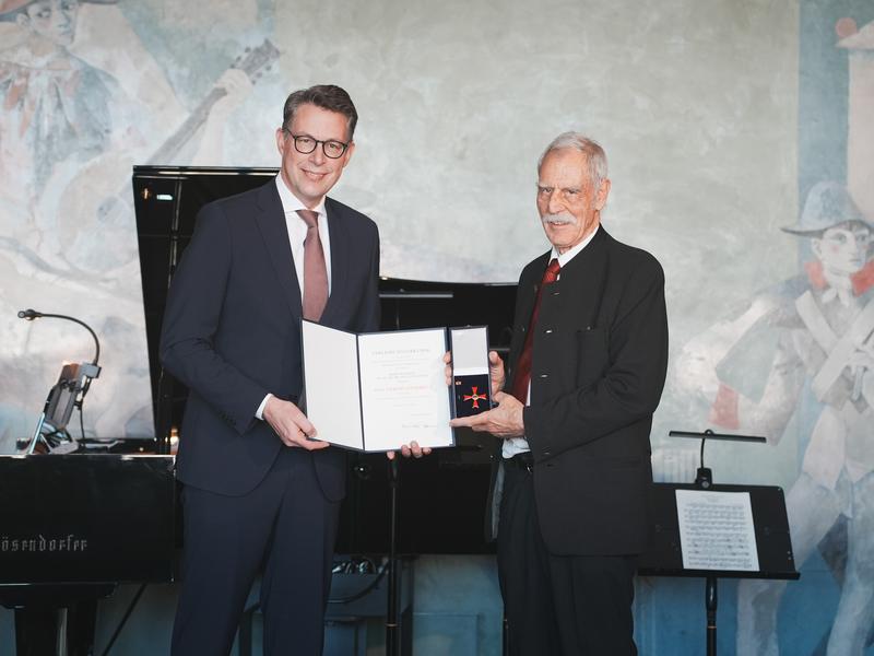 Bayerns Wissenschafts- und Kunstminister Markus Blume überreicht Prof. Lutz Gürtler in München das Bundesverdienstkreuz 1. Klasse.