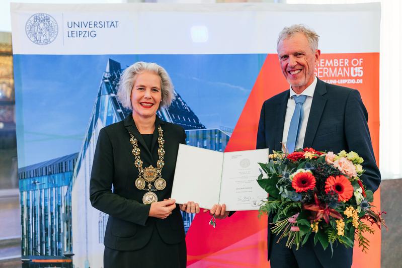 Die Rektorin der Universität Leipzig, Eva Inés Obergfell, überreicht Sebastian Lentz die Ernennungsurkunde zum Seniorprofessor