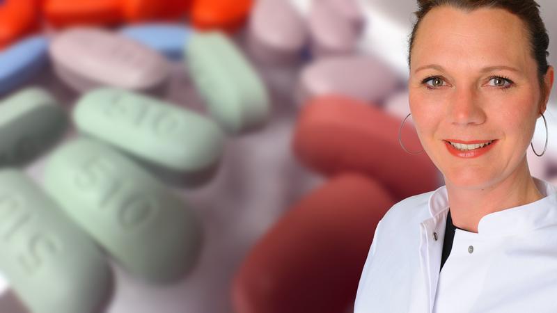 DZIF-Wissenschaftlerin Prof. Dr. Clara Lehmann; im Hintergrund antiretrovirale Medikamente, die zur Behandlung von HIV eingesetzt werden.