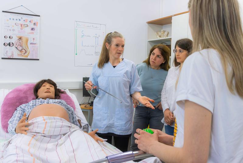 A trainer from the Faculty of Medicine explains the birth simulation model to the participants. 