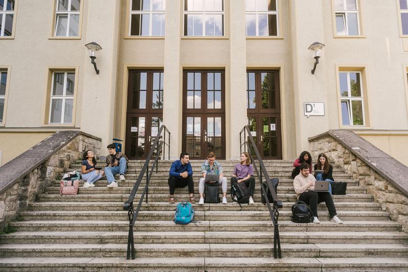 Studierende vor dem Audimax am Campus Treskowallee der HTW Berlin.