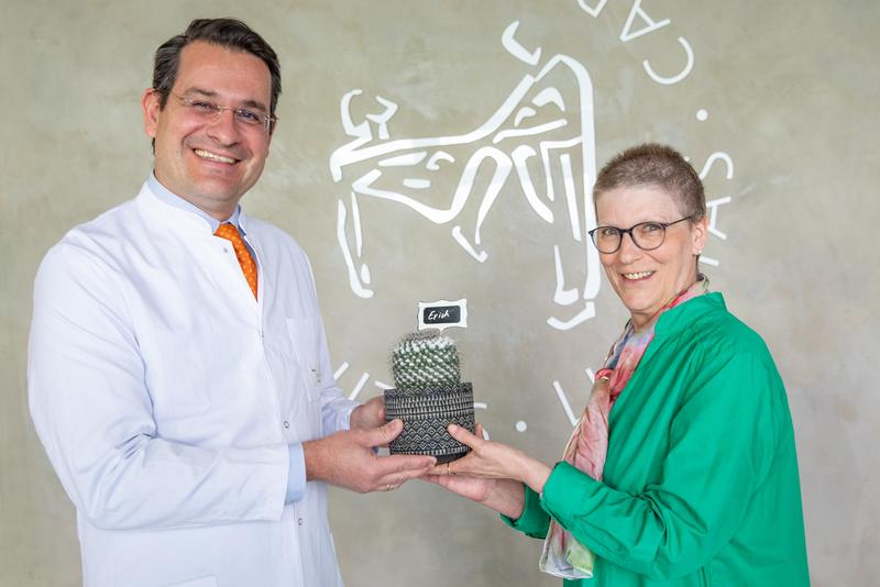 Susanne Viehmeier überreicht Prof. Moritz Schmelzle den Kaktus namens Erich.