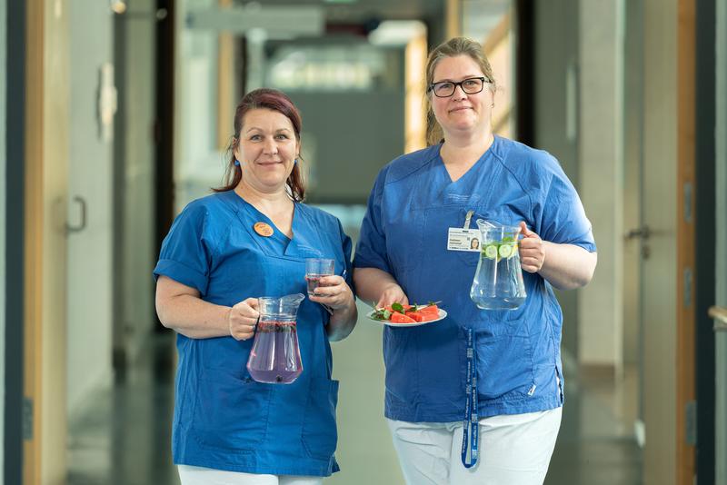 Die Pflegeexpertinnen Katja Kniese (l.) und Kathleen Hartrampf engagieren sich am Uniklinikum Dresden im interdisziplinären Ernährungsteam. Zum Hitzeaktionstag machen sie auf die Gefahren großer Hitze aufmerksam und geben hilfreiche Tipps.