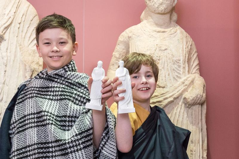 Gekleidet in römischen Gewändern präsentieren die Nachwuchsforscher die selbst gegossenen Figuren