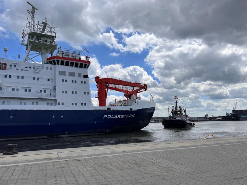 Die Polarstern startet aus ihrem Heimathafen Bremerhaven Richtung Arktis. Ein Schlepper zieht das Schiff Richtung Schleuse. 