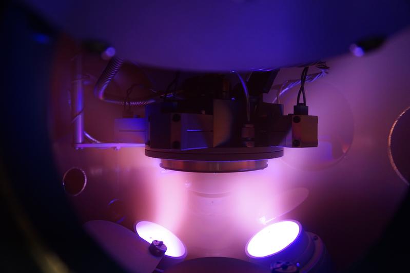 Argon-Plasma in der Vakuumkammer beim Magnetron-Sputtern, mit dem Substrat in der Bildmitte. 