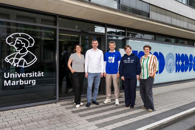 Universitätspräsident Prof. Dr. Thomas Nauss (Mitte) präsentiert das neue Corporate Design mit Projektleiterin Andrea Ruppel (2. von rechts) sowie (von links) Claudia Heesch, Florian Riedel und Leonie Vogel von der amatik Designagentur. 