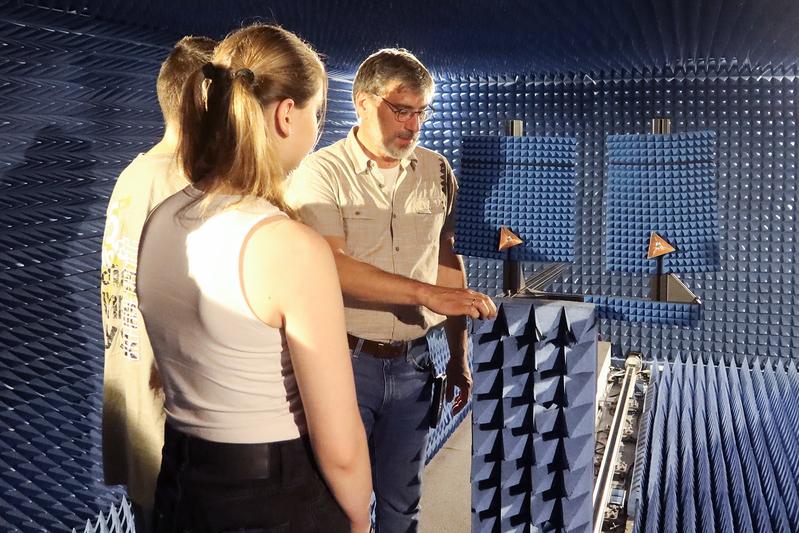 IHP-Wissenschaftler Jürgen Berthold erläutert einer kleinen Gruppe die Funktionen und Messmöglichkeiten in der Antennenmesskammer.