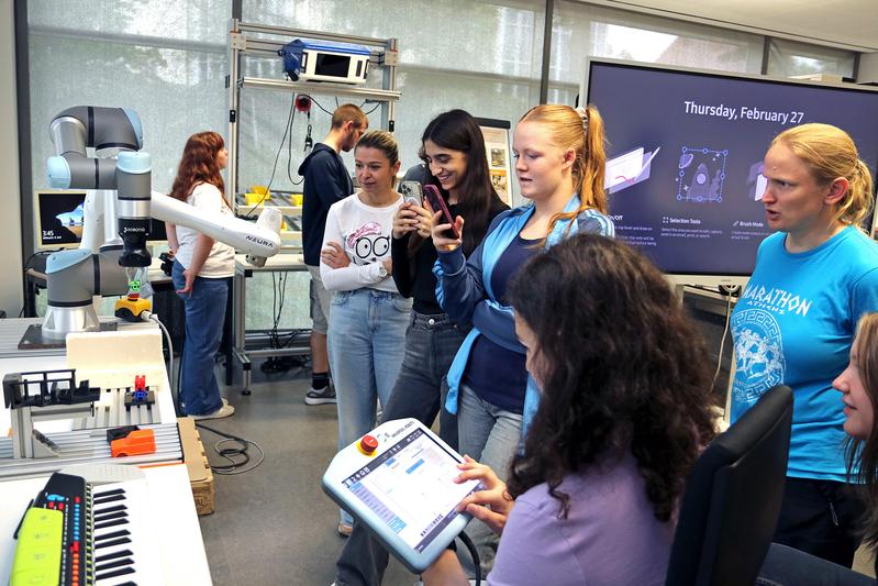 Prof. Dr. Dorit Borrmann (re.) beobachtet den finalen Lauf des Roboterarms, der von den Schülerinnen gefilmt wird