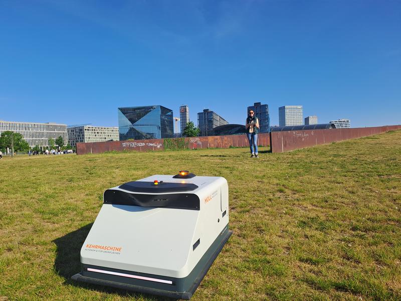 Die Technikphilosophin Lena Fiedler beobachtet den Reinigungsroboter im Spreebogenpark.