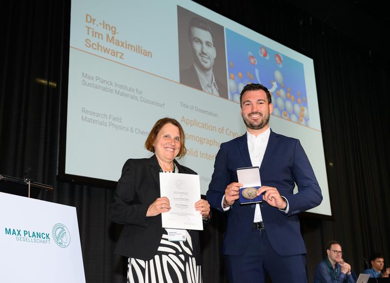Prof. Claudia Felser, Vizepräsidentin der MPG, überreicht Dr. Tim M. Schwarz die Otto-Hahn-Medaille für seine herausragende Doktorarbeit.