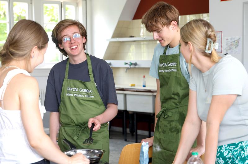 Spannende Naturwissenschaften in entspannter Arbeitsatmosphäre: Schüler und Studentinnen im Austausch über den optimalen "Erbsen-Burger"