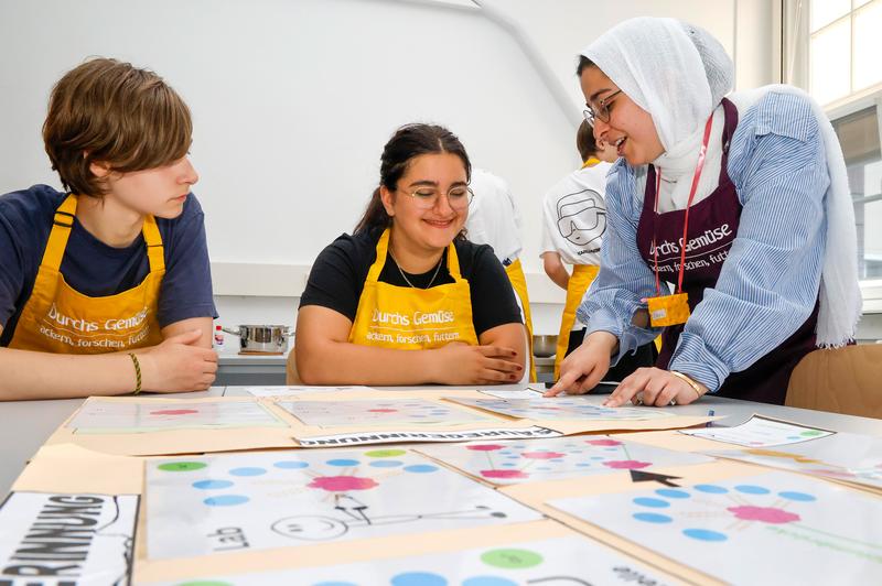 Alles Käse? Studierende erläutern einer Schülerin ein wenig Theorie der Käseherstellung.