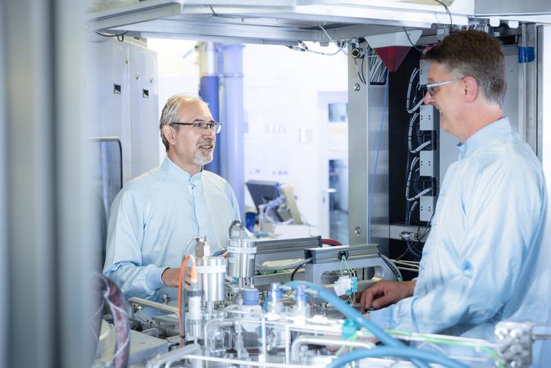 Dr. Dan Buca (links) und Andreas Tiedemann (rechts) an der CVD-Anlage von AIXTRON, mit der der Wafer beschichtet wurde.