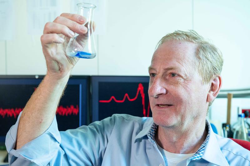 Projektleiter Prof. Dr. Winfried Plass vom Institut für Anorganische und Analytische Chemie der Universität Jena betrachtet den Kristall einer Kupferverbindung, mit der das Team seine Untersuchungen zu Spin-Zuständen in Molekülen durchgeführt hat.