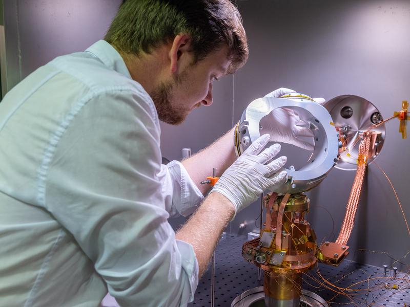 IPP scientist Paul Huslage assembles a model coil in the test stand. This allows magnetic coils to be examined at temperatures of 20 Kelvin (-253 degrees Celsius) under vacuum conditions.