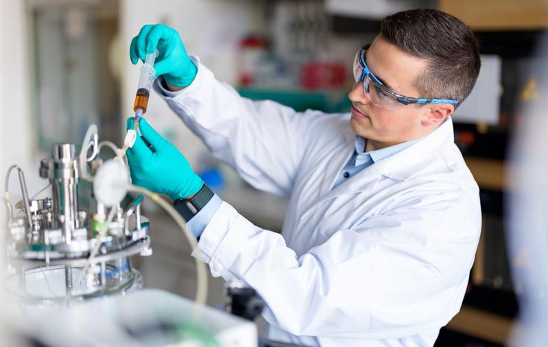 Bioverfahrenstechniker Dr.-Ing. Sven Göbel bei seiner Forschungsarbeit in einem Labor des Max-Planck-Instituts in Magdeburg, hier bei der Probenahme einer aus einem Bioreaktor zur Analyse der Virusausbeute.