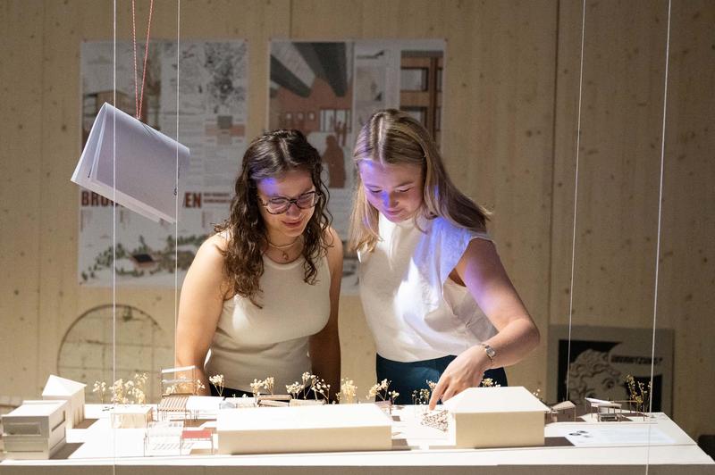 Theresia Dill und Charlotte Ebert schauen sich bei der Werkschau der Fakultät Design + Bauen der Hochschule Coburg um. Den beiden Architekturstudentinnen aus dem zweiten Semester gefallen die visionären hkeiten die höheren Semester.