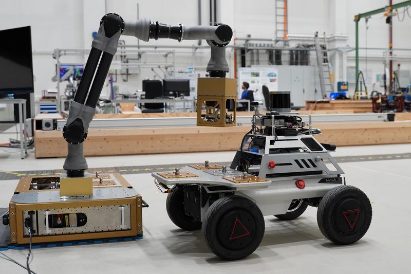 Erfolgreich demonstriert: Der am DFKI entwickelte modulare Manipulatorarm übergibt das Nutzlastmodul über eine multifunktionale Schnittstelle an den Rover HUNTER SE. 