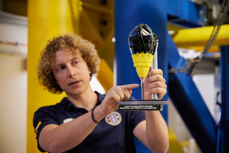 Projektingenieur Marvin Raupert mit einem Modell, das den 3D-Druckprozess veranschaulicht. 