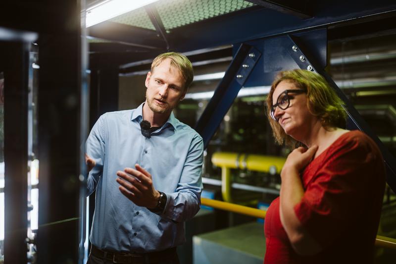 Prof. Dr. Rico Meier (HTW Berlin) vom Promotionszentrum "Energiesystemtransformation und Klimaneutralität" erläutert Dr. Ina Czyborra das AUMUND-Versuchsbecherwerk und die damit verbundenen Forschungsarbeiten zur industriellen Sensorik an der HTW Berlin.